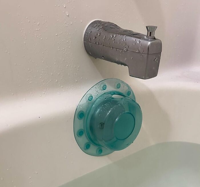 Bathtub faucet and a blue suction cup bath toy holder, a popular bathroom must-have for organization and convenience.
