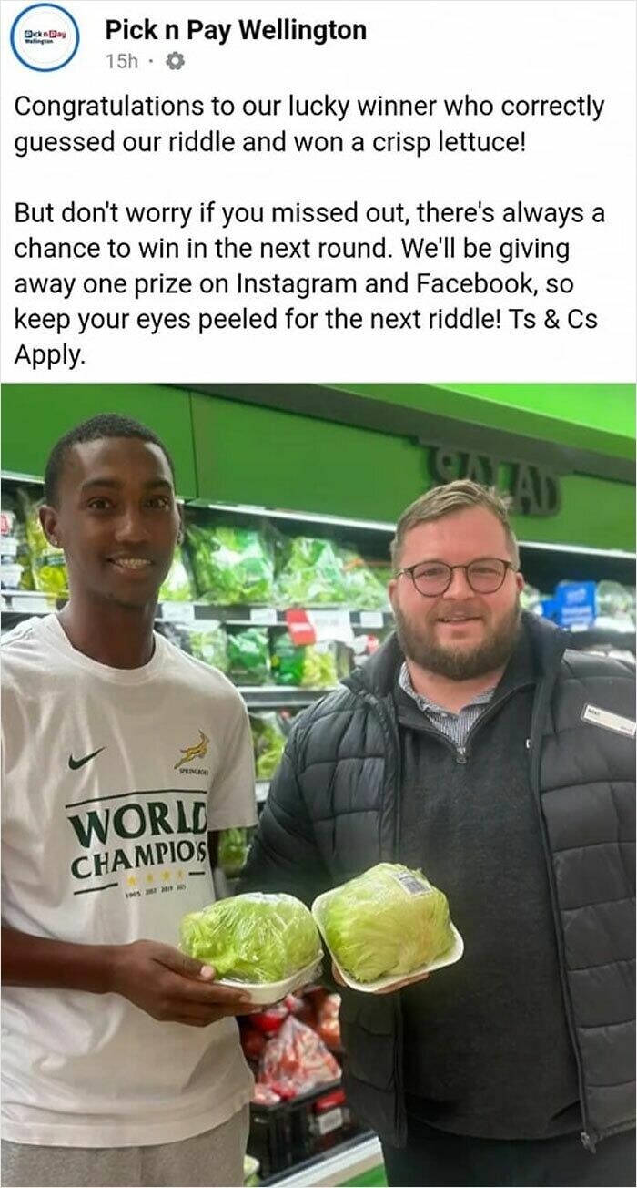 Two men smiling in a store holding lettuce, showcasing embarrassing behavior in a light-hearted promotion.