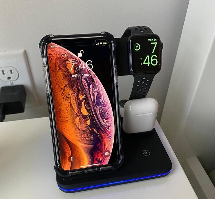 Smartphone, smartwatch, and earbuds charging on a sleek wireless dock, showcasing perfect tech gadget organization.