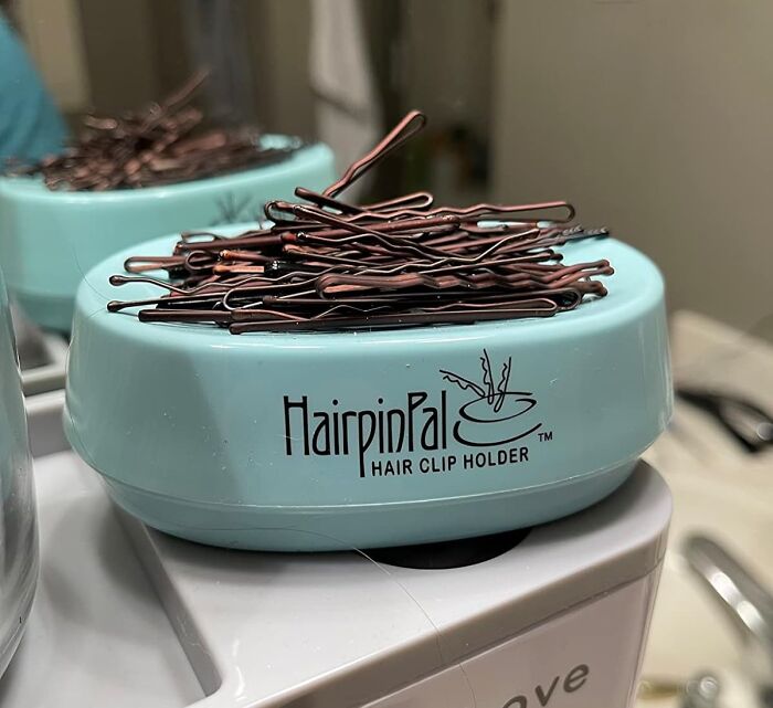 Blue HairpinPal hair clip holder with brown bobby pins stacked on top, ideal daily organization tool.