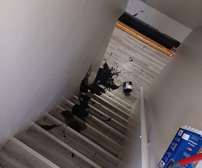 Pintura negra derramada en escaleras, mostrando una escena clara de un mal día para una persona.