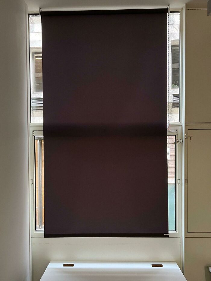 Failed repair attempt with a misaligned blackout blind covering a window, highlighting a DIY issue.