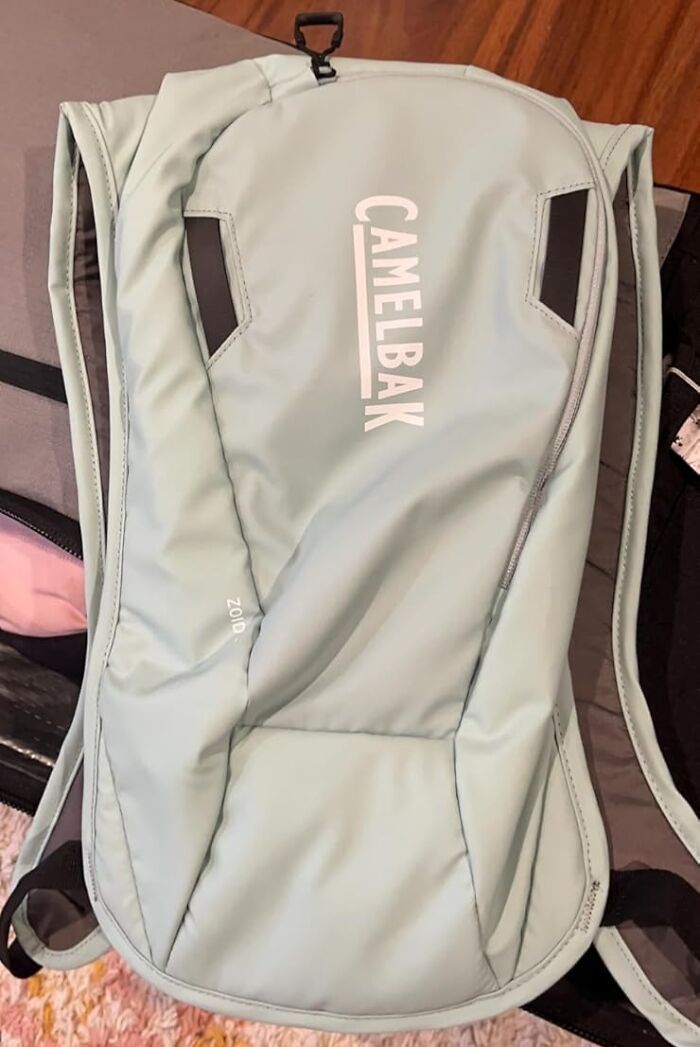 Light blue CamelBak backpack, ideal for festival survival, displayed on a wooden floor.