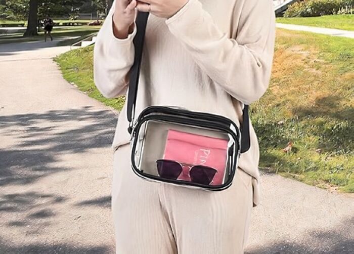 Clear crossbody bag with essentials for a festival, featuring a pink pouch and sunglasses, perfect for a survival kit.