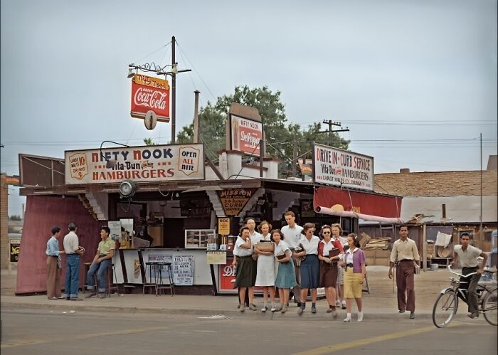 A vintage hamburger stand with people gathered outside, evoking nostalgia for history enthusiasts.