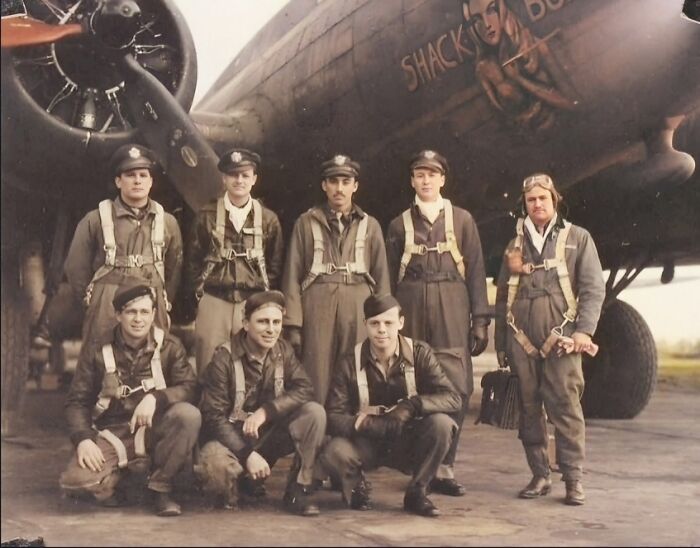 Group of WWII pilots in front of their aircraft, wearing uniforms and flight gear, showcasing historical aviation moments.