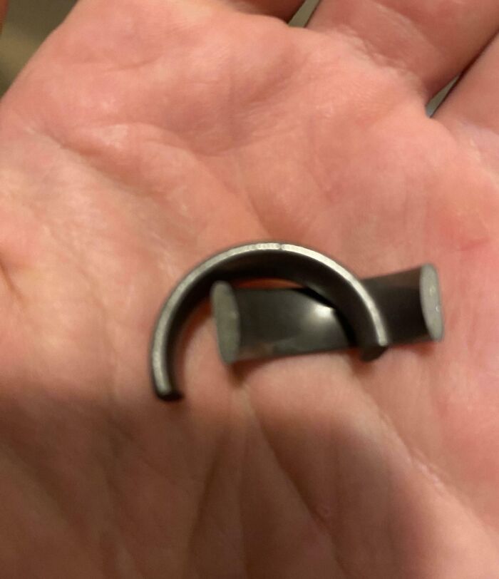 Mano sosteniendo pieza metálica doblada que representa una de las 30 personas que seguramente estén teniendo un mal día.