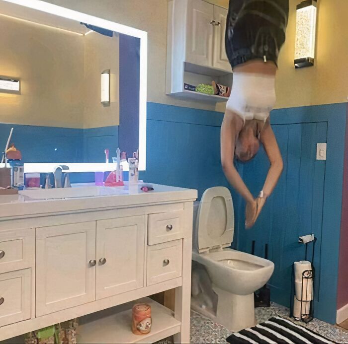 Person posing upside down in a quirky bathroom.