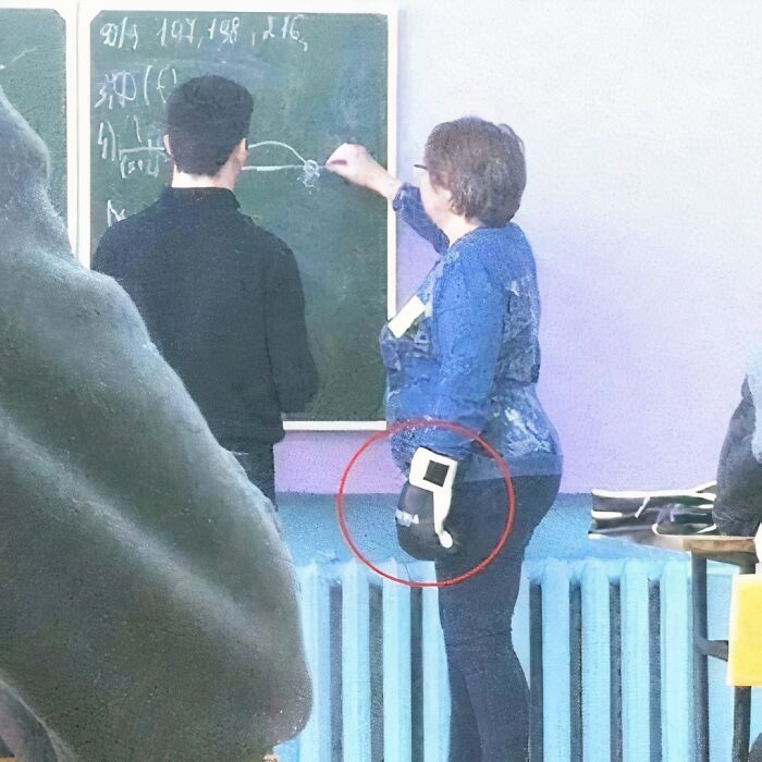 Person at chalkboard, another holding boxing glove; humorous moment captured.