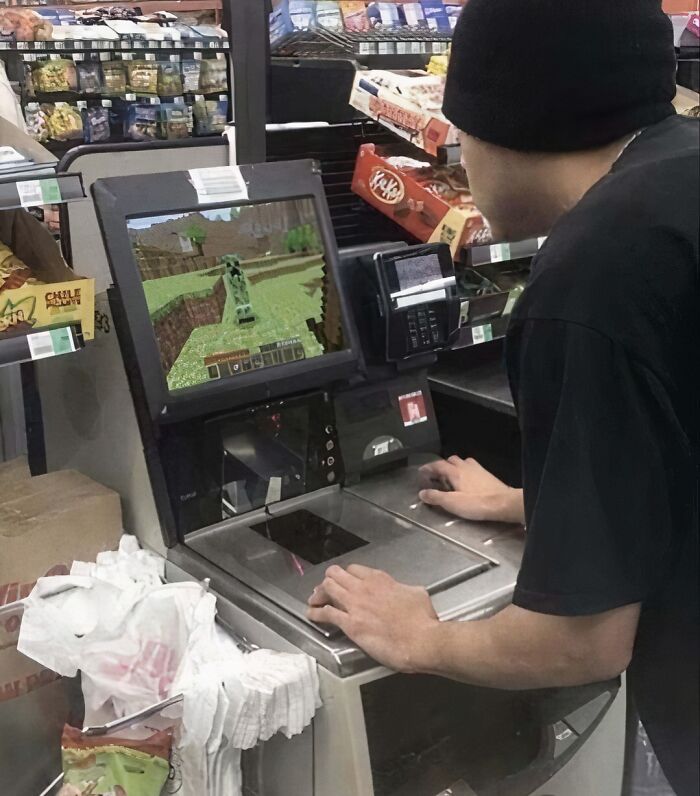 A person playing Minecraft at a grocery store self-checkout, creating a humorous and unusual scene.