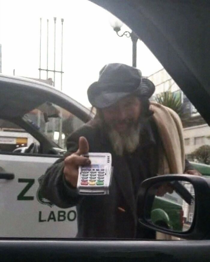Man in hat offering a card reader through car window, illustrating content from a popular IG page.