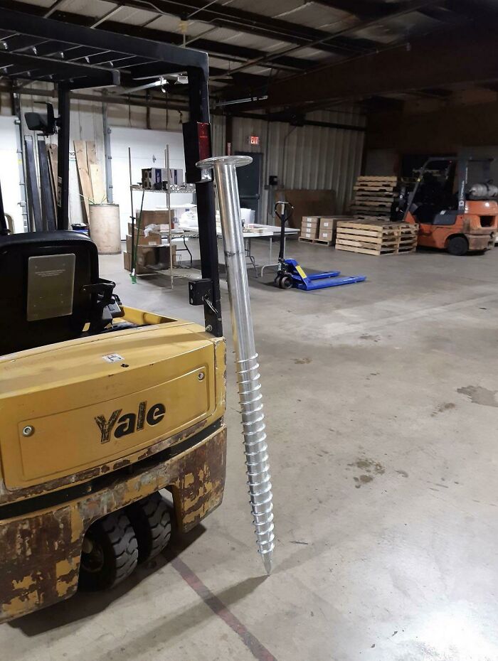 Forklift holding a giant s***w standing on the warehouse floor, looking surreal but real.