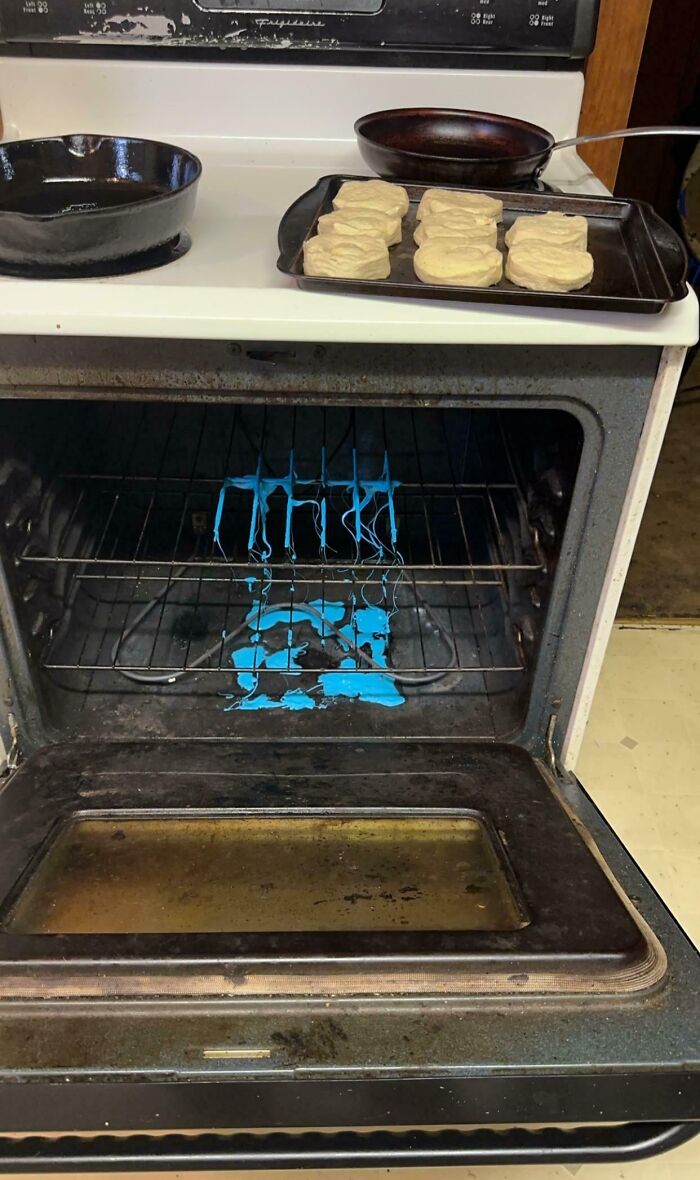 Oven mishap with melted blue plastic; tray of unbaked biscuits on top. Horrible day kitchen fail.