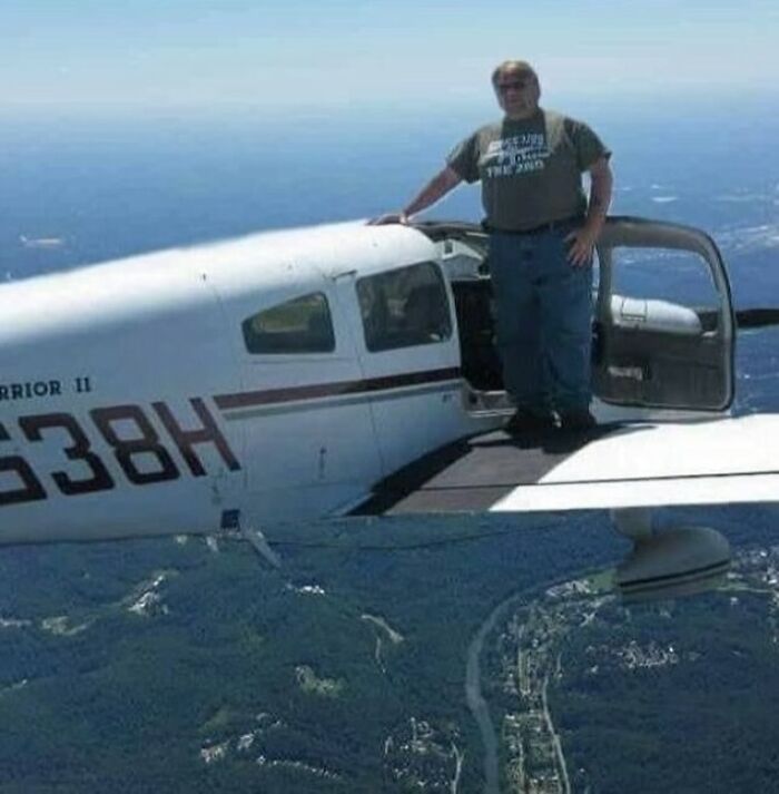 Person standing on small aircraft wing mid-flight, showcasing a daring and humorous pose for an Instagram post.