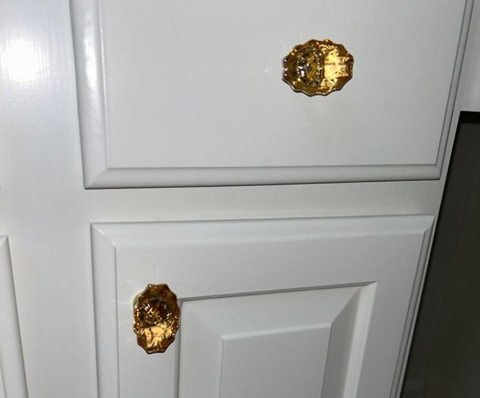 White cabinet with gold decorative knobs, showcasing show-stopping finds.