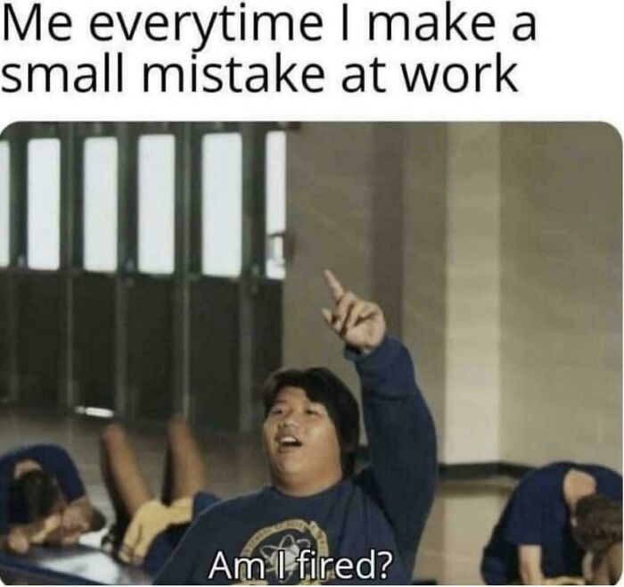 Person humorously raising hand, asking "Am I fired?" after a small work mistake.