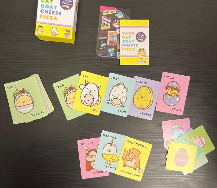 Easter themed card game with illustrations including tacos, cats, and goats, spread across a table.