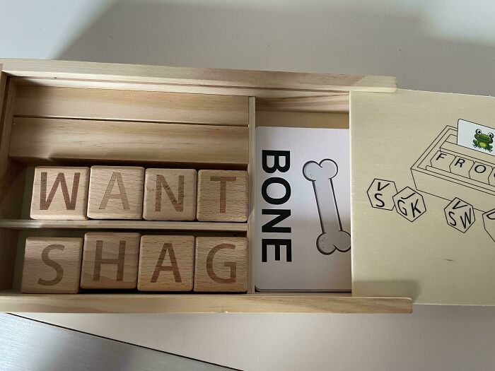Wooden letter blocks spell humorous message with a bone card, showcasing a funny moment in a man's life.