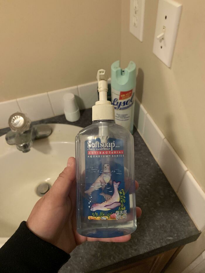 Elderly humor with an empty soap bottle in a bathroom setting, showcasing a playful seal design.