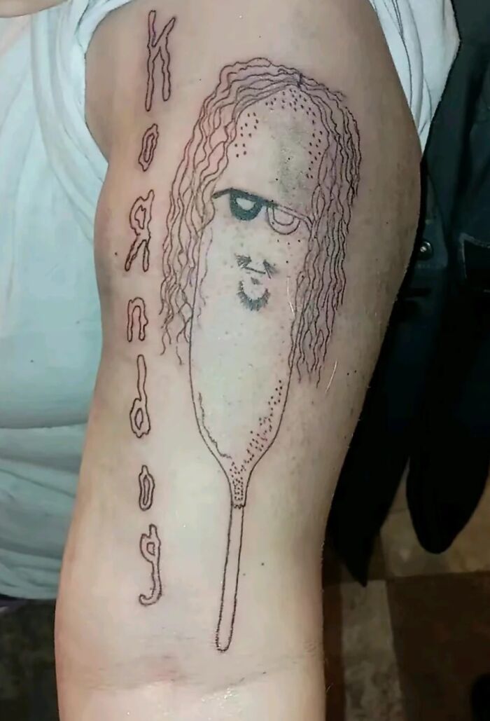 "Amusingly bad tattoo of a corn dog with a face, showcasing humor in body art."