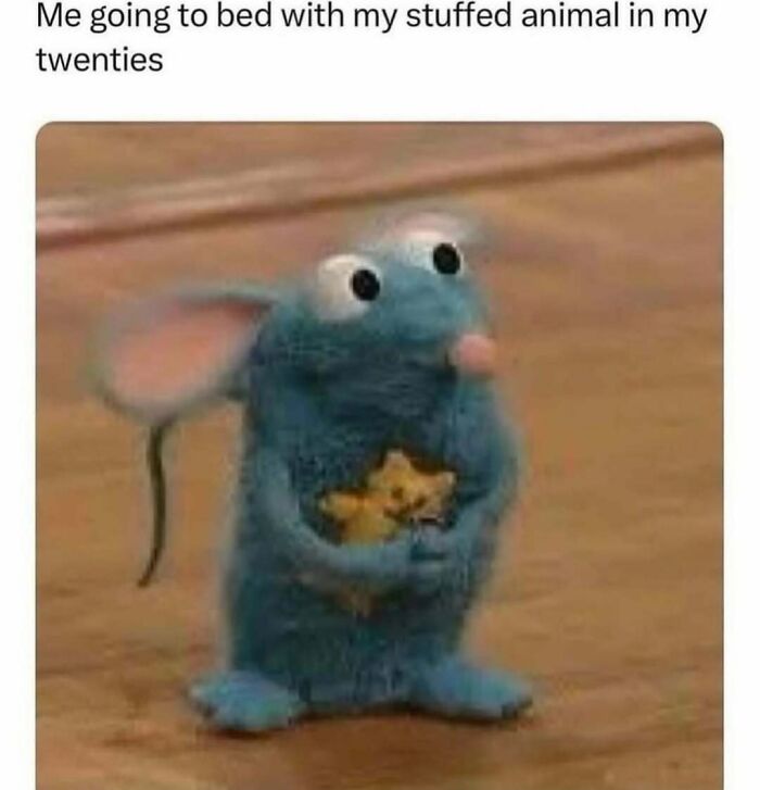 A plush blue mouse holding a small stuffed animal, capturing a relatable moment in adulthood.