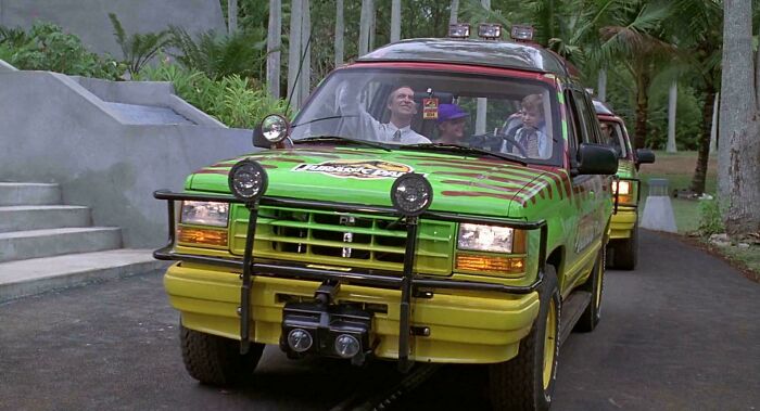 Colorful vehicle from a movie, showcasing creative filmmaker prop design, driving on a tropical path.