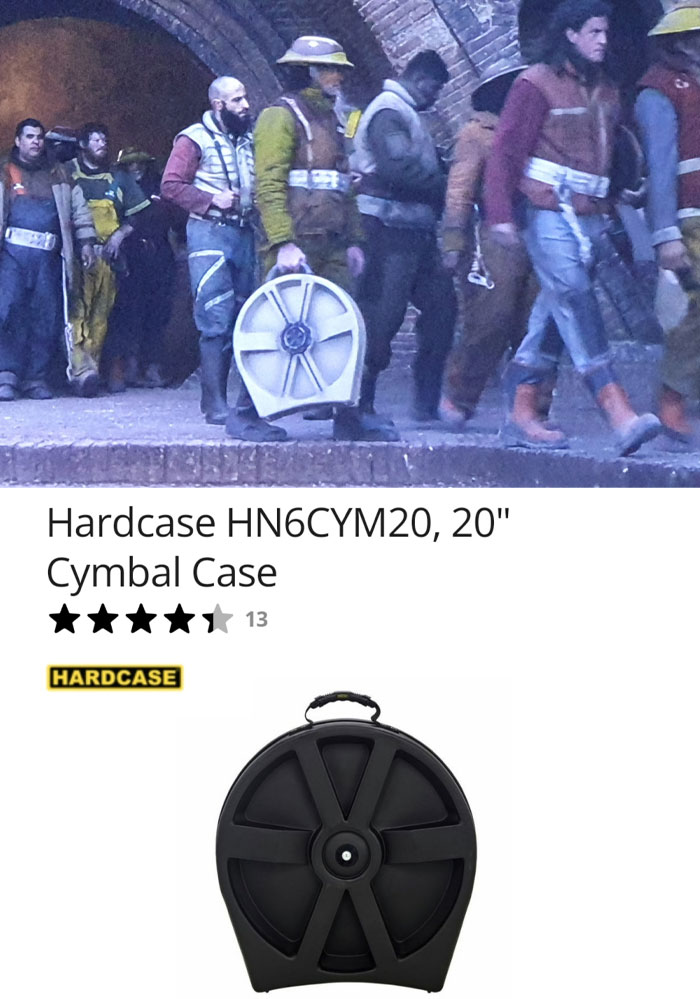 Film crew using a creative prop resembling a cymbal case in a scene.