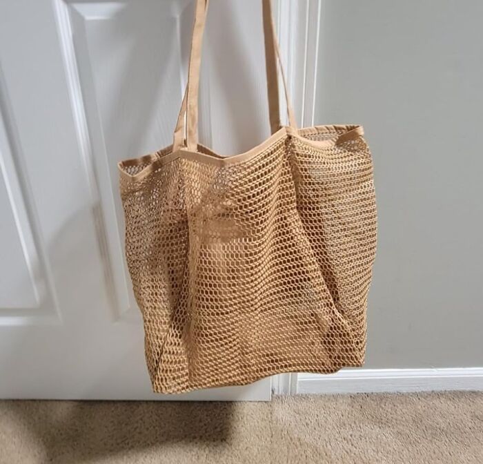 Vintage mesh tote bag hanging on a door, triggering millennial nostalgia with its retro design.