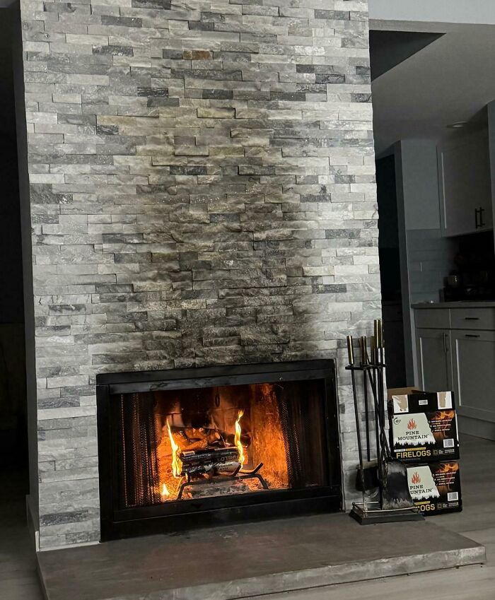 Fireplace with a charred stone wall above, showing potential danger signs.
