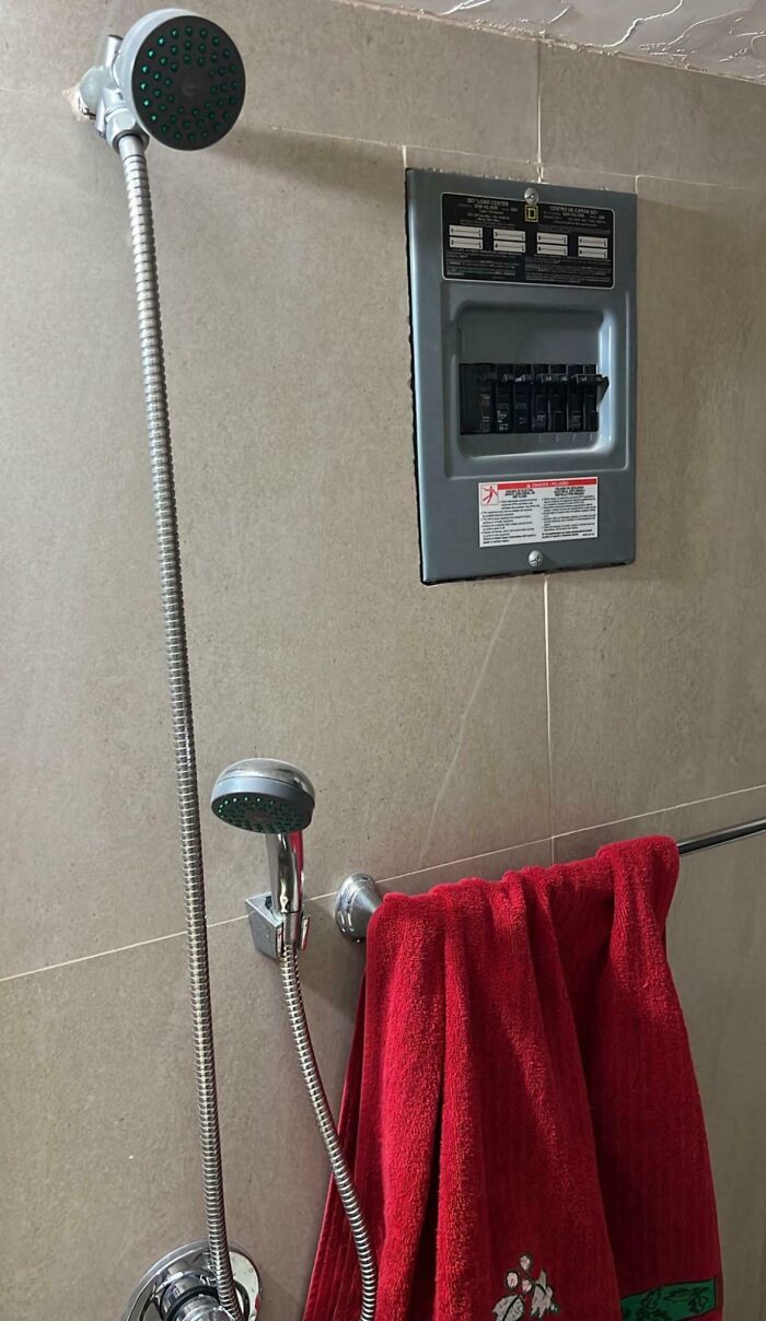 Shower with electrical panel, illustrating a dangerous setup in a bathroom.