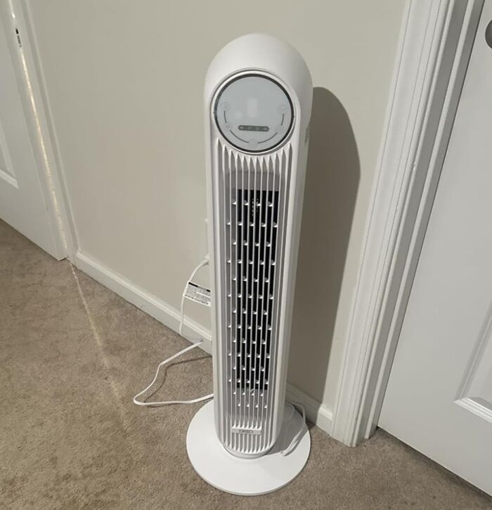 Tall white tower fan on beige carpet in a room corner, part of Amazon movers and shakers selection.