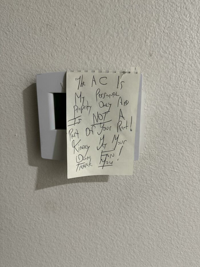 Note taped on thermostat, claiming AC is personal property, not included in rent, reflecting landlord horror stories.