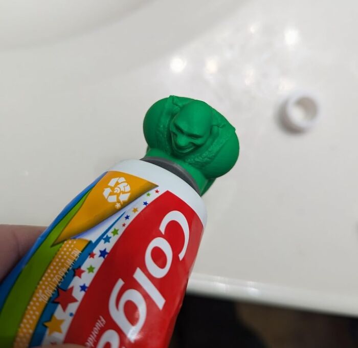 Unusual toothpaste with a unique green cap, resembling a crouching figure, showcasing a ridiculous find.