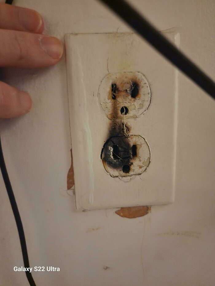 Burnt electrical outlet with visible damage, illustrating issues with horrific landlords.