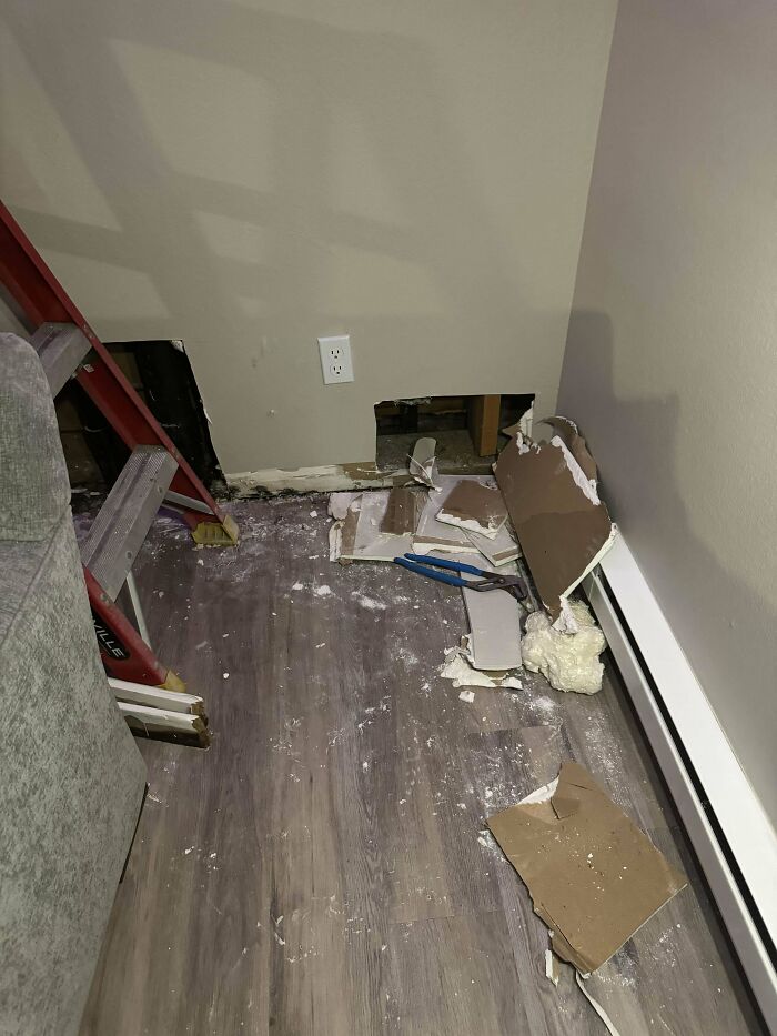 Damaged wall with debris on the floor, highlighting issues with landlords.