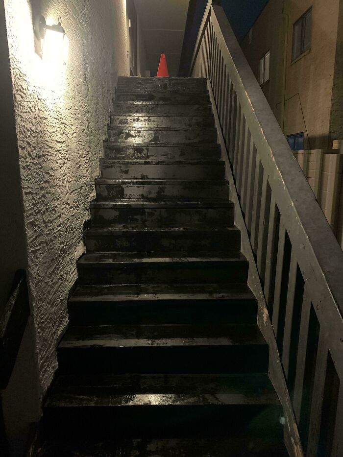 Wet, hazardous staircase with a caution cone, illustrating stories of horrific landlords.