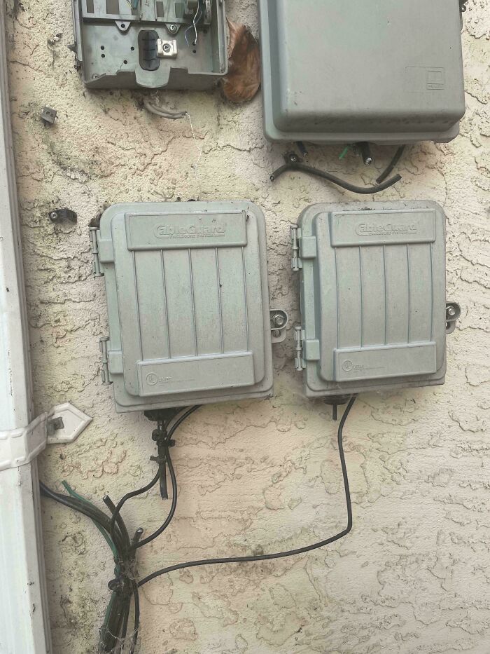 Electrical boxes on a wall, with exposed wires, highlighting landlord issues.