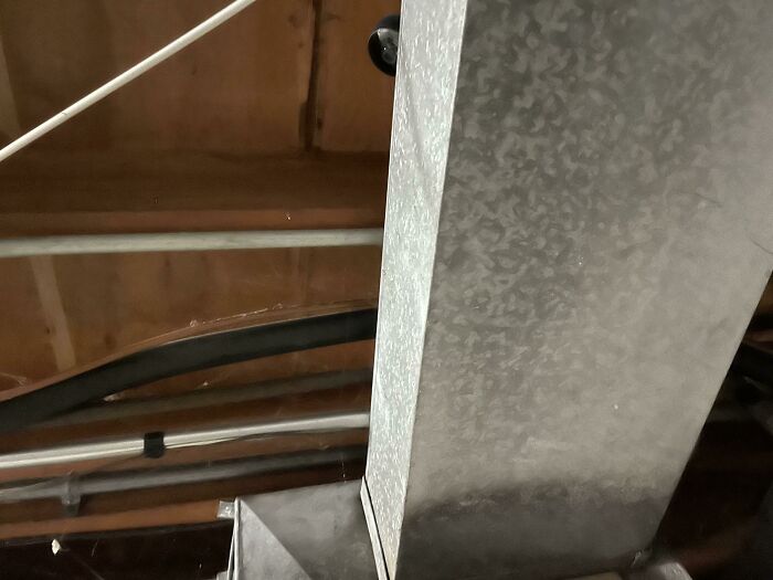 Metal ductwork running through an unfinished basement ceiling, highlighting landlord maintenance issues.