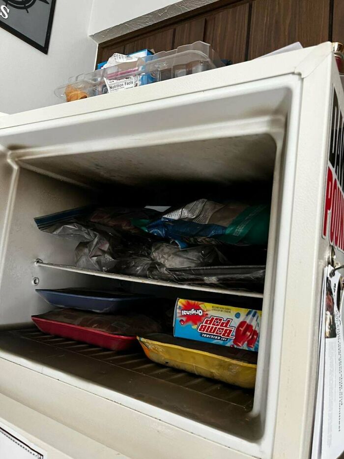 Freezer filled with various frozen food items and cardboard packs representing landlord issues.