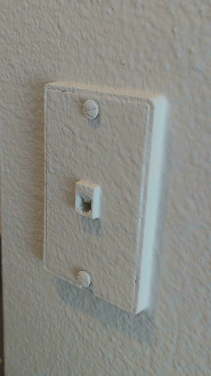 Painted-over light switch, showcasing a landlord’s neglect.