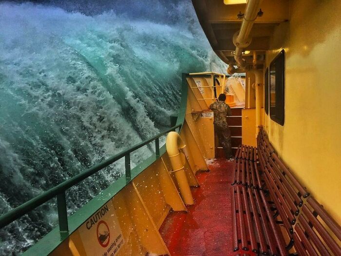Massive ocean wave crashing onto a ship deck, capturing the terrifying power of the sea.