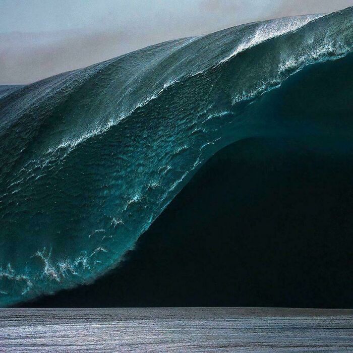 Massive ocean wave towering above, capturing the power and mystery of the sea.