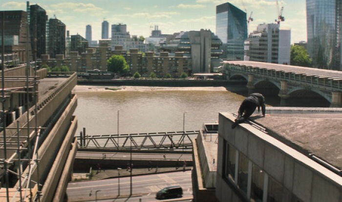 Actor performing a challenging rooftop stunt during a difficult role in an urban cityscape, showcasing commitment to acting.