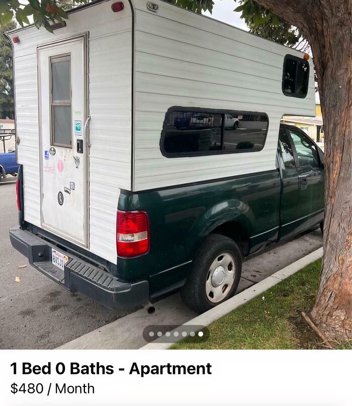 Truck with a camper shell parked on the street, listed as a one-bedroom apartment at $480/month.