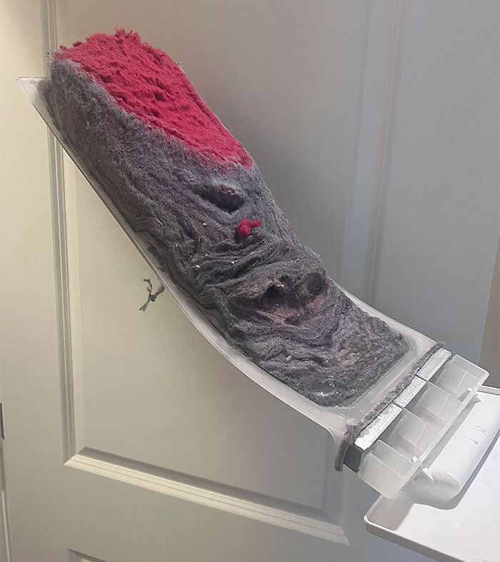 Dryer lint trap dangerously overfilled, posing a fire hazard.