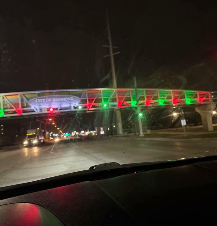Dangerous bridge with colorful lights at night from a car's perspective.