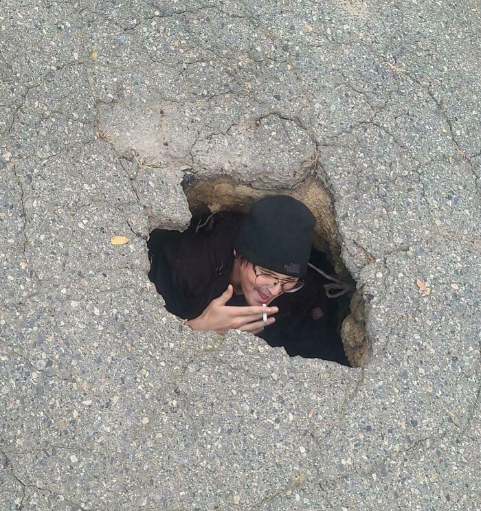 Persona asomándose desde un agujero en el suelo, ilustrando peligro inadvertido.