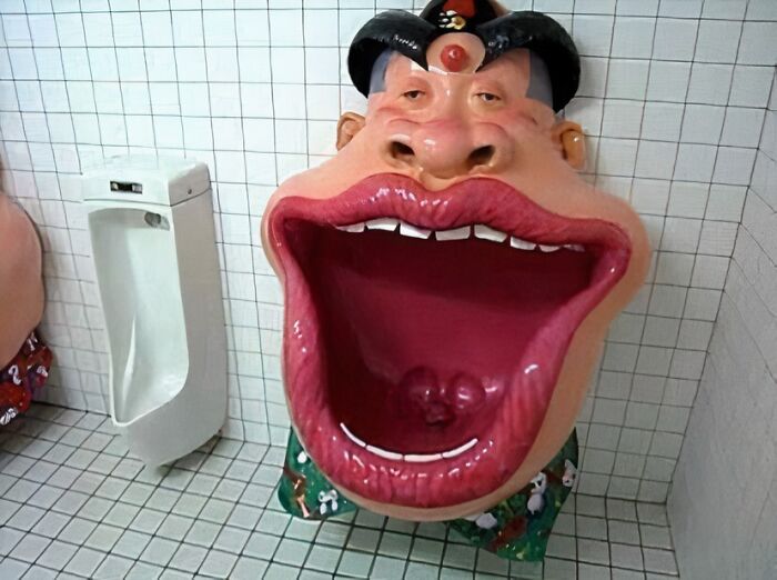 Unique urinal design with a large mouth face in a tiled restroom, showcasing random cursed images theme.