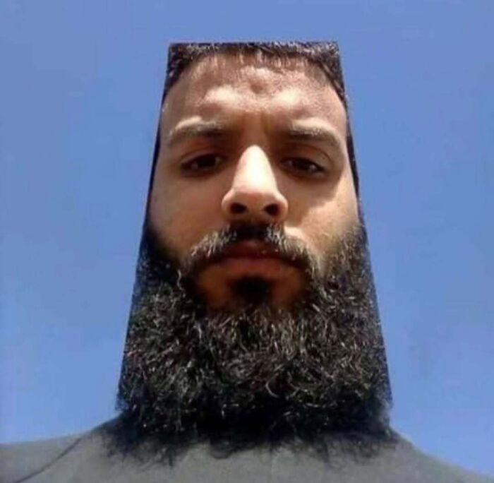 A person with a square beard style under a clear blue sky, representing random cursed images.