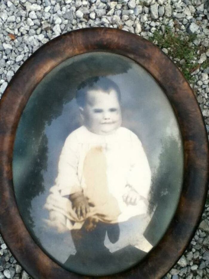 A creepy vintage photo of a child in an oval frame, found hidden in a home.